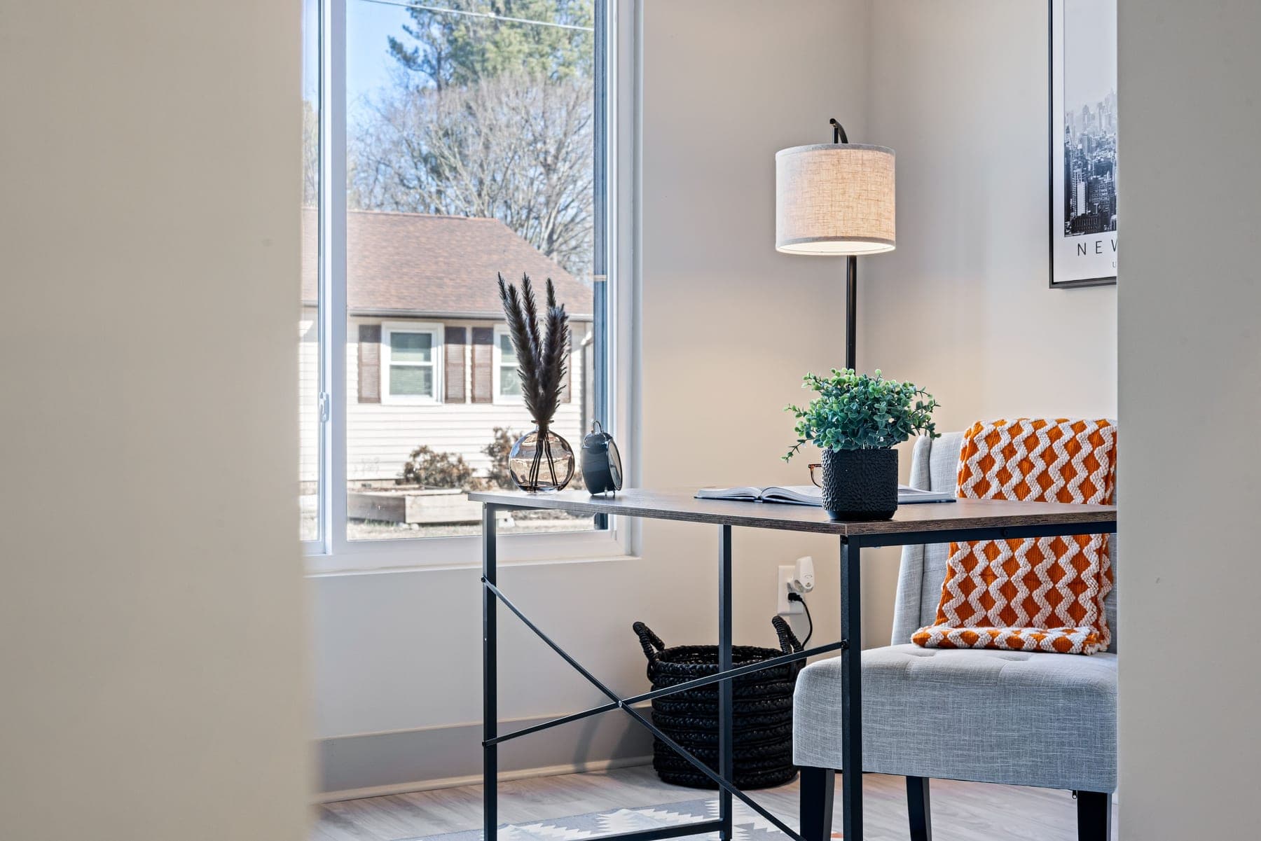 A calm home office desk with a notebook and warm daylight from a window